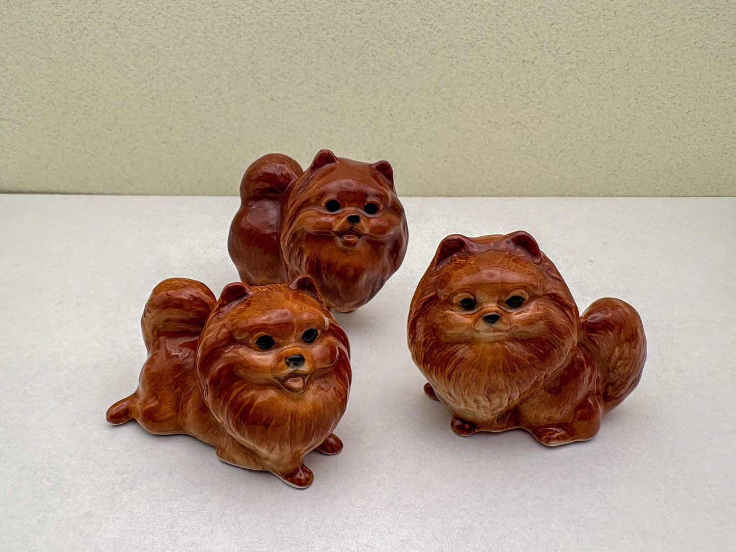 Ceramic Reddish-Brown Pomeranian Figurine Trio – Adorable Dog Statues in Standing, Sitting and Laying Poses, Perfect for Home Décor