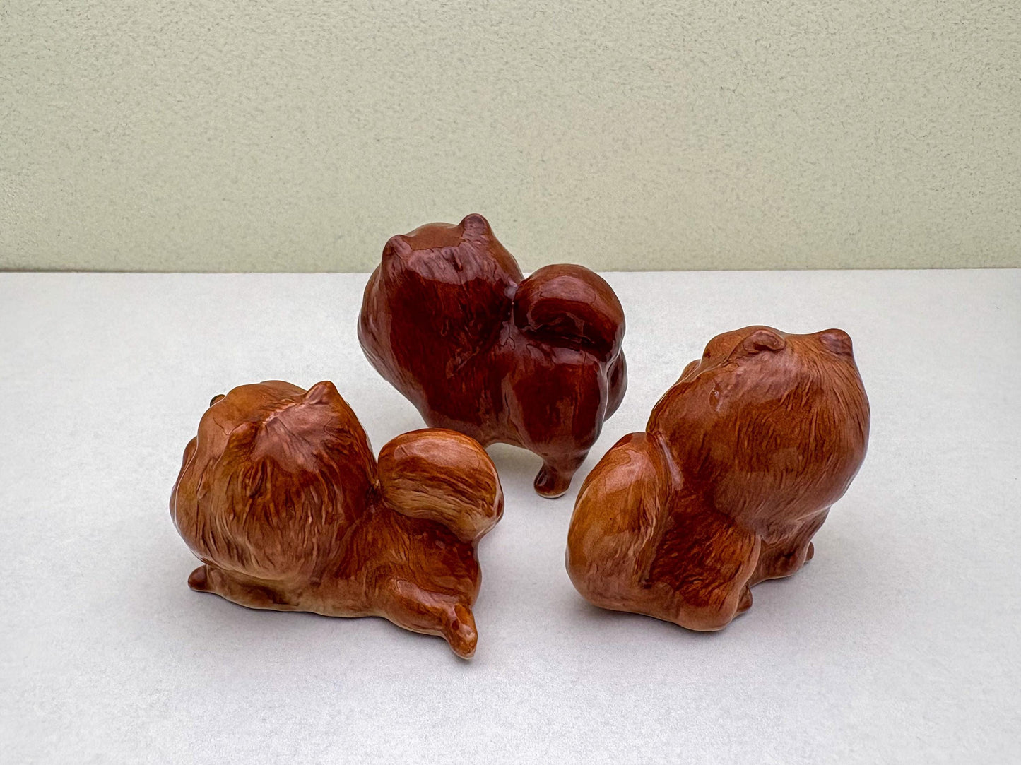 Ceramic Reddish-Brown Pomeranian Figurine Trio – Adorable Dog Statues in Standing, Sitting and Laying Poses, Perfect for Home Décor